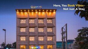 Un edificio moderno con un cartel que dice “goSTOPS” y el eslogan “Aquí reservas sensaciones, no solo un alojamiento”.