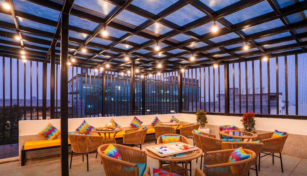 Una terrazza dall'estetica curata con vista sulla città, con mobili in vimini e tetto in vetro.