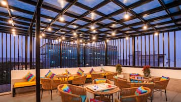 Una terrazza dall'estetica curata con vista sulla città, con mobili in vimini e tetto in vetro.