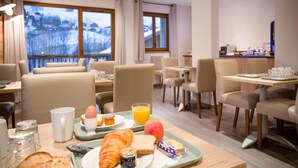 A breakfast setup with croissants, toast, jam, a croissant, a glass of orange juice, and a red apple on a tray. - Apartment in Beaufort Near Ski Trails (Beaufort)