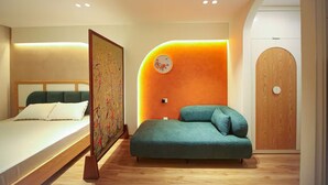 Un dormitorio moderno con cama, sofá y puerta de madera.