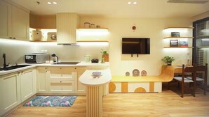Una cocina moderna con armarios blancos, estufa integrada y una isla central.