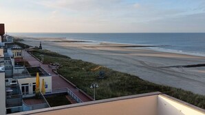 A coastal hotel with a view of the beach, a parking area, and a small garden. - Beach Villa Marina 26 Sea View (Wangerooge)