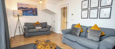 A living room with two grey sofas, a wooden coffee table, and a floor lamp.