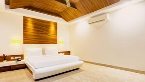 A modern bedroom with a wooden ceiling, a white bed, and a marble floor. - Mordern Rooftop Restro and Pool at Udaipur (Udaipur)