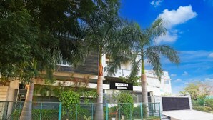 A building named "PALETTE" with a sign, surrounded by greenery and a fence. - Mordern Rooftop Restro and Pool at Udaipur (Udaipur)