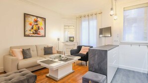 A modern living room with a sofa, a coffee table, and a TV. - Charming Apartment - 2br/4p- Javel (Paris)