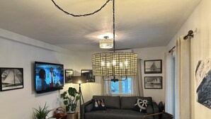 A cozy living room with a sofa, TV, and decorative items.