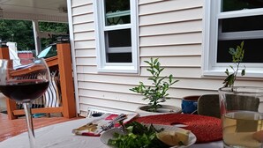 A dining table with a red placemat, a glass of red wine, and a plate of food. - Rustic Elegance: Farmhouse Retreat In Covington (Covington)