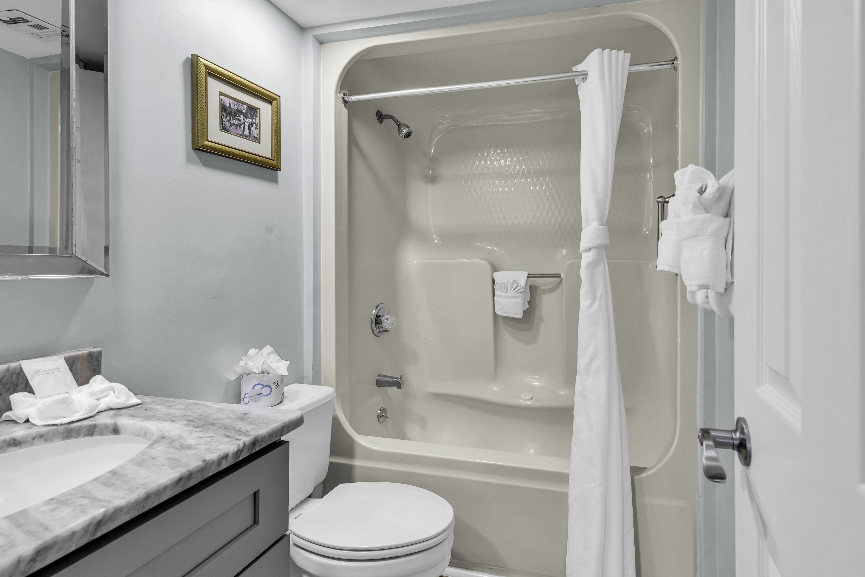 Un baño con bañera, inodoro y tocador.