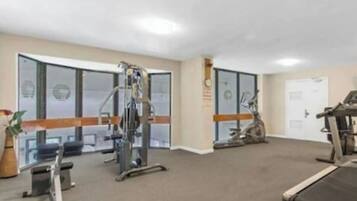 A gym with various exercise equipment including treadmills, stationary bikes, and weight machines.