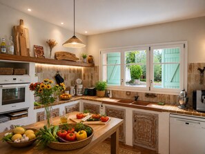A kitchen with a wooden table, a hanging light fixture, and a window with shutters. - NEW Spacious Villa  Pool Peaceful  8 Guests  Verdon, Provençal Villages & Sea (Draguignan)