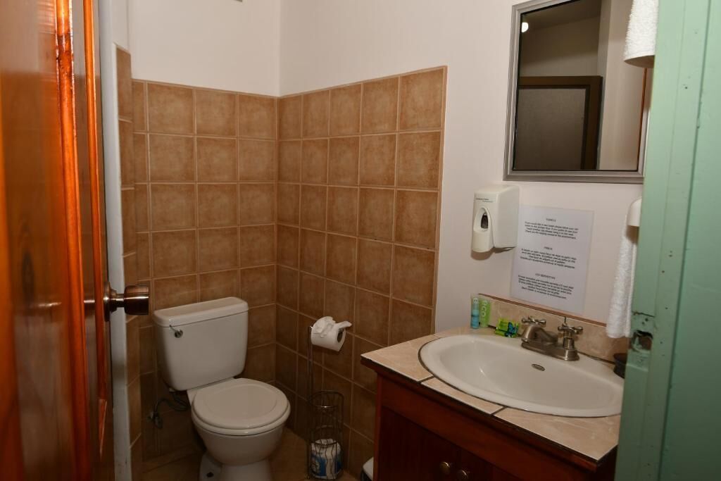 Un baño con inodoro, lavabo y espejo.