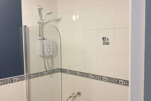 Een douche, handdoeken, zeep, toiletpapier