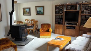 A cozy living room with a fireplace, a television, and a bookshelf. - TRANQUIL RETREAT IN GRAYLAND - Minutes from Westport's Coast (Grayland)