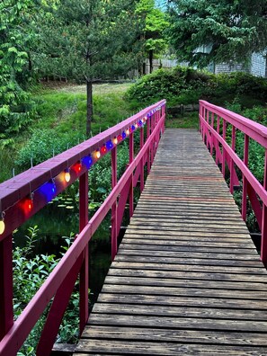 Un puente de madera con barandillas rojas y luces de colores.