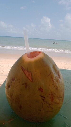 Enjoy a refreshing coconut drink on our beachside table.