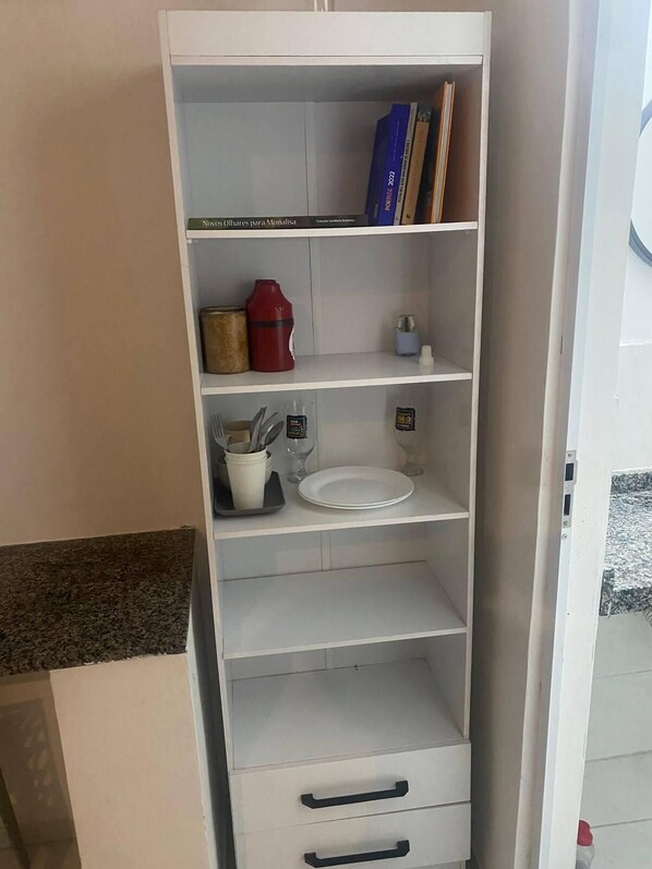 A fully equipped kitchenette with a wall-mounted cabinet and drawer.