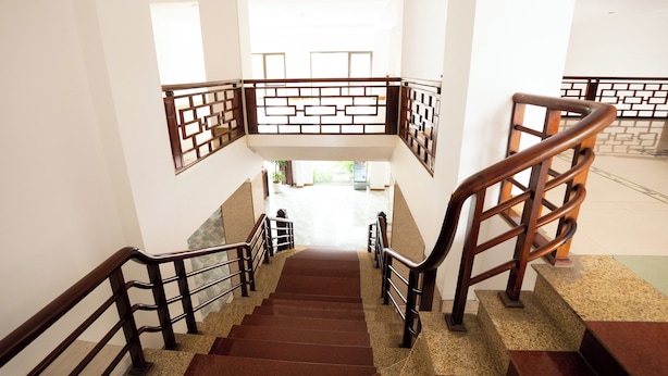 A staircase with wooden railings and a patterned wall design. - Kim Thanh Hotel (Vinh Phuc)