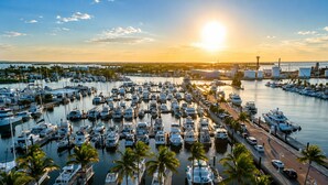 A marina with numerous boats docked, surrounded by palm trees and a clear sky. - Sailboat Stay • Marina Pools • Sleeps 4 • Stock Island, Key West (Key West)