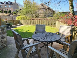 A patio with wooden furniture and a stone wall. - Luxury Dog Friendly Cottage - Golf & Spa Breaks (Totnes)