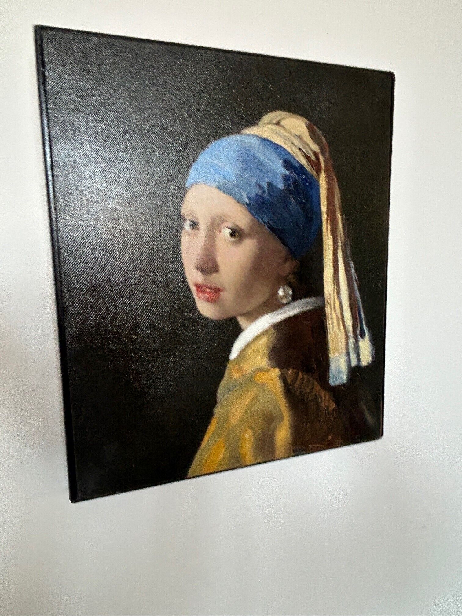 A portrait of a person wearing a blue headscarf and a yellow garment with a white collar.