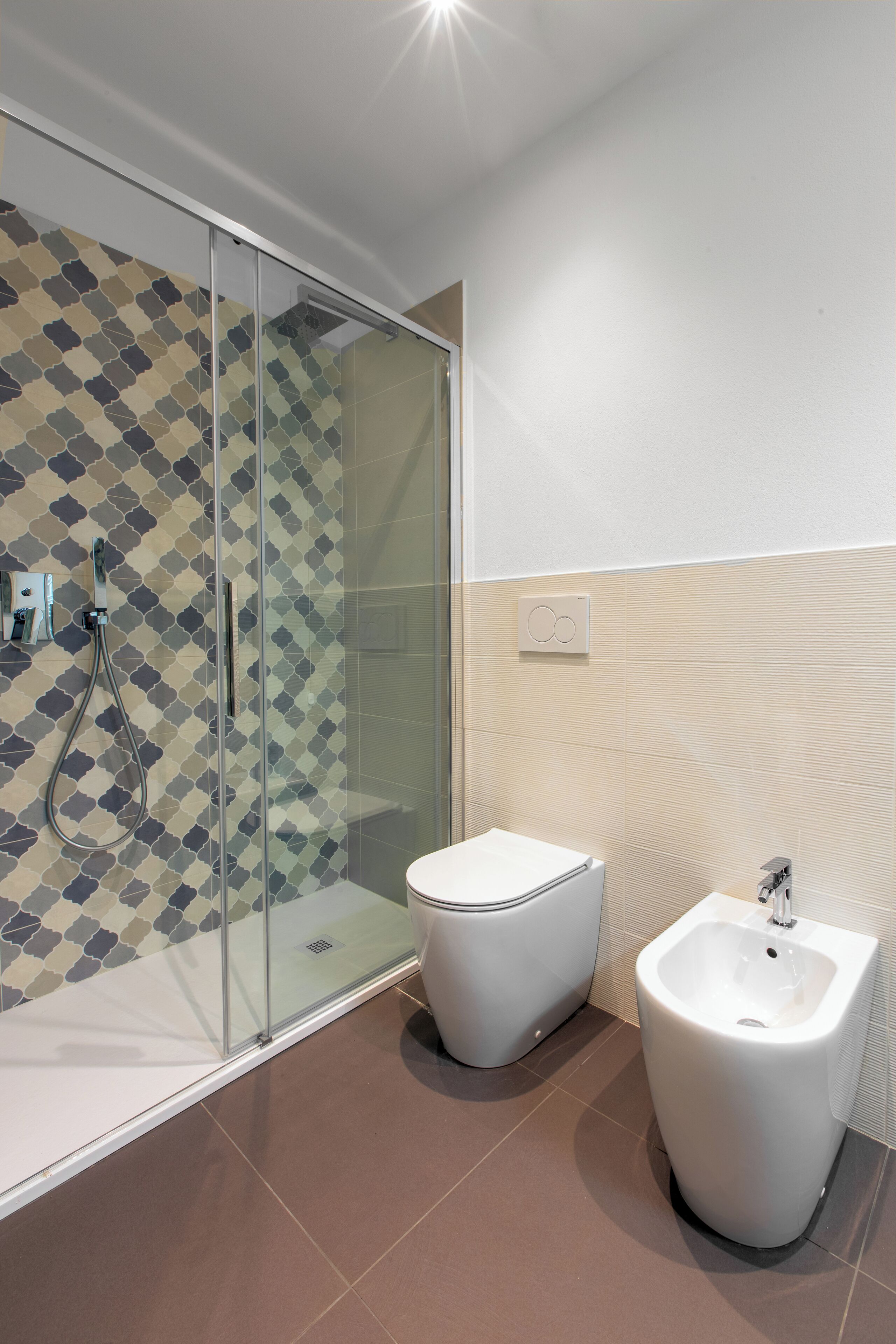 Ein modernes Badezimmer mit Duschkabine aus Glas, Toilette und Bidet.