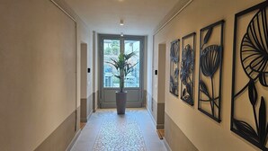 Un pasillo con piso de baldosas, una planta en maceta y decoración en la pared.