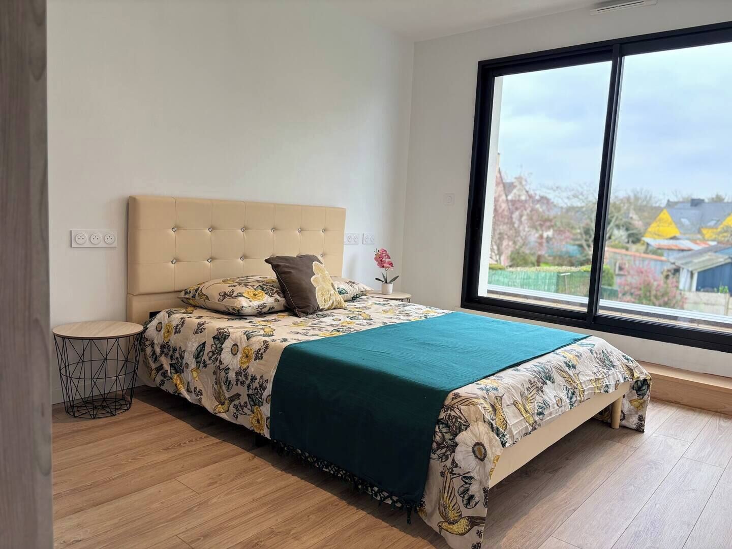 Ein Schlafzimmer mit einem großen Bett, einem Fenster mit Blick und einem kleinen Nachttisch.