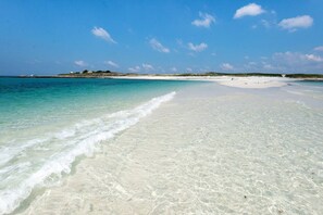 Une plage à l’eau turquoise et au sable blanc.