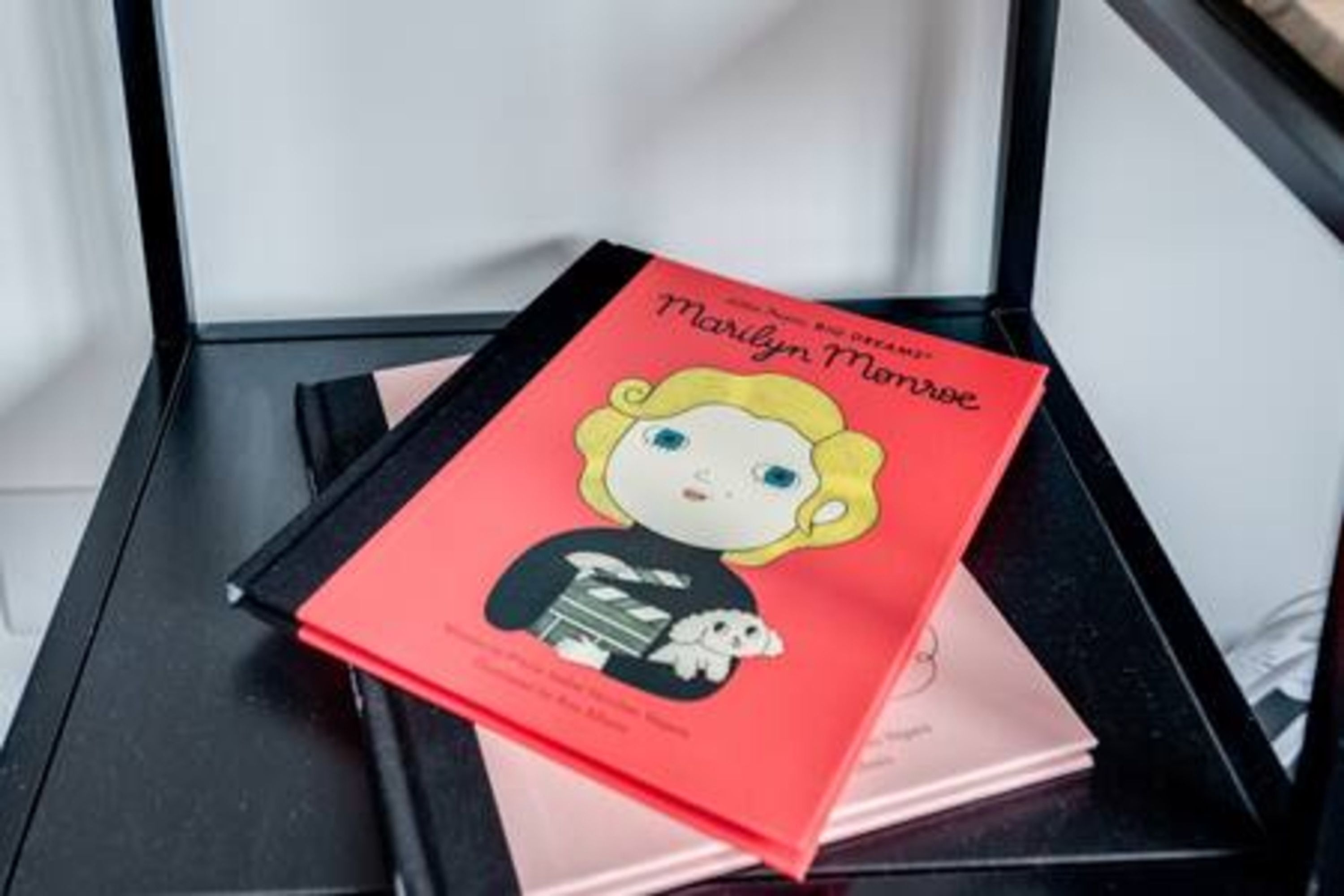 Un libro con el título 'Marilyn Monroe' sobre una superficie negra.