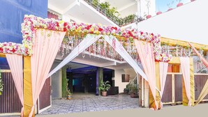 A decorated entrance with floral arrangements and draped fabric. - Cozy Stays Near Doon University, Dehradun (Dehradun)