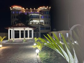 Un edificio bien iluminado con un pabellón central y un balcón.
