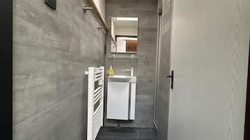 Een douche, handdoeken, toiletpapier