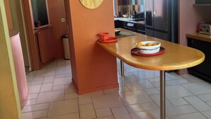 Une cuisine moderne dotée d’un îlot central, de luminaires suspendus et d’un grand réfrigérateur.