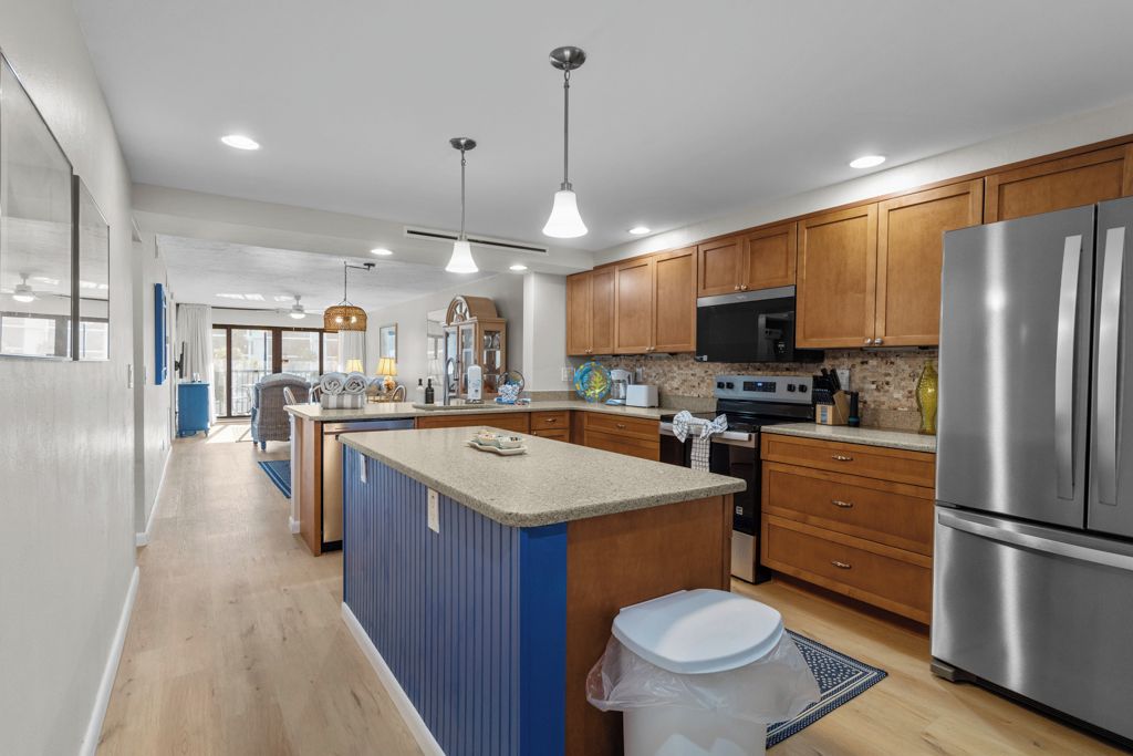 A modern kitchen with wooden cabinets, stainless steel appliances, and a central island.