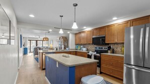 Una cocina moderna con armarios de madera, electrodomésticos de acero inoxidable y una isla central.