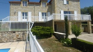 A two-story stone building with balconies, a swimming pool, and a well-maintained garden. - Spacious Holiday Home in Monsegur With Pool (Monsegur)