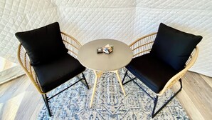 A room with a round table and two black cushioned chairs.