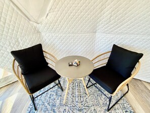 Ein Zimmer mit einem runden Tisch und zwei schwarzen, gepolsterten Stühlen.