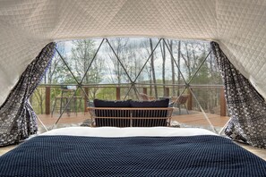 A tented accommodation with a bed, a view of trees, and a deck with chairs. - Romantic Mountain Retreat - Hot Tub - Winter Views (Todd)