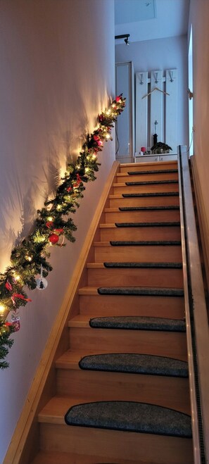A staircase with wooden steps and a garland of lights and ornaments. - Vacation apartment Petze (Sibbesse)