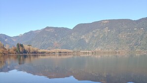 A calm lake with clear reflections of the surrounding mountains and trees. - Calafquen adventure Hostel y cabañas (Conaripe)