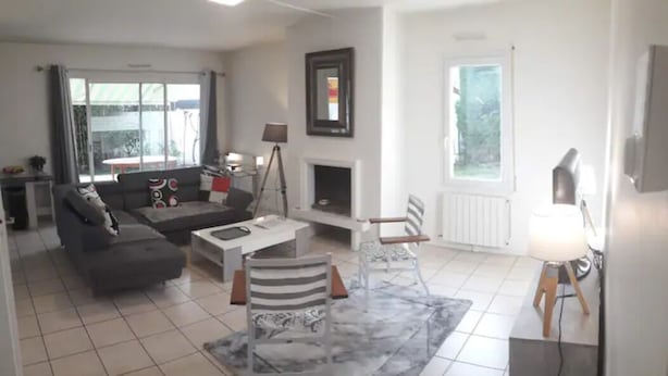Un salon moderne avec un canapé, une table basse et une cheminée.