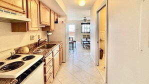 A kitchen with wooden cabinets, a stove, and a sink.