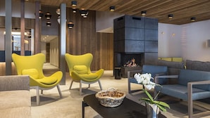A modern lobby with wooden ceiling, yellow armchairs, a grey sofa, and a fireplace. - Wifi, ski-in/ski-out & foot of the slopes, swimming pool, hammam, terrace, balcony, tv, ski locker (Les Saisies)
