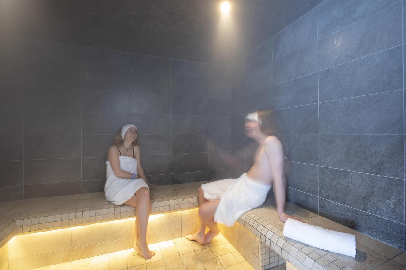 Un hammam aux murs et aux bancs recouverts de carreaux.