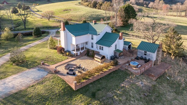 A large white house with a green roof, a patio with outdoor furniture, and a swimming pool. - Branch and Barrel: Hot Tub & Sauna + Mtn Views (Roseland)