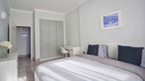 Un dormitorio con cama, escritorio y armario.