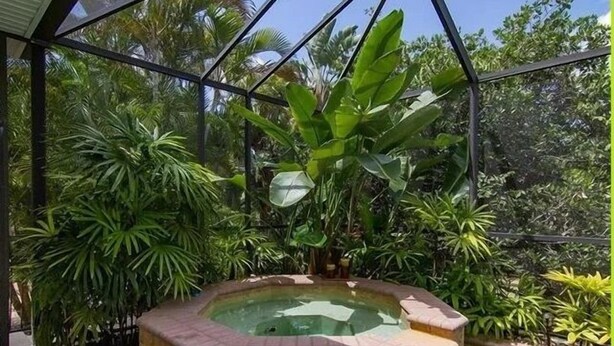 A hot tub surrounded by lush tropical plants, with a clear view of the surrounding greenery. - Gorgeous Paradise Village boating community on the Imperial River (Bonita Springs)